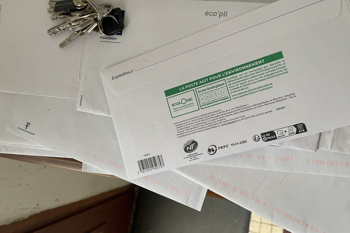 « Pile de courrier en attente et trousseau de clés à l'entrée d'un logement, illustration du surendettement »