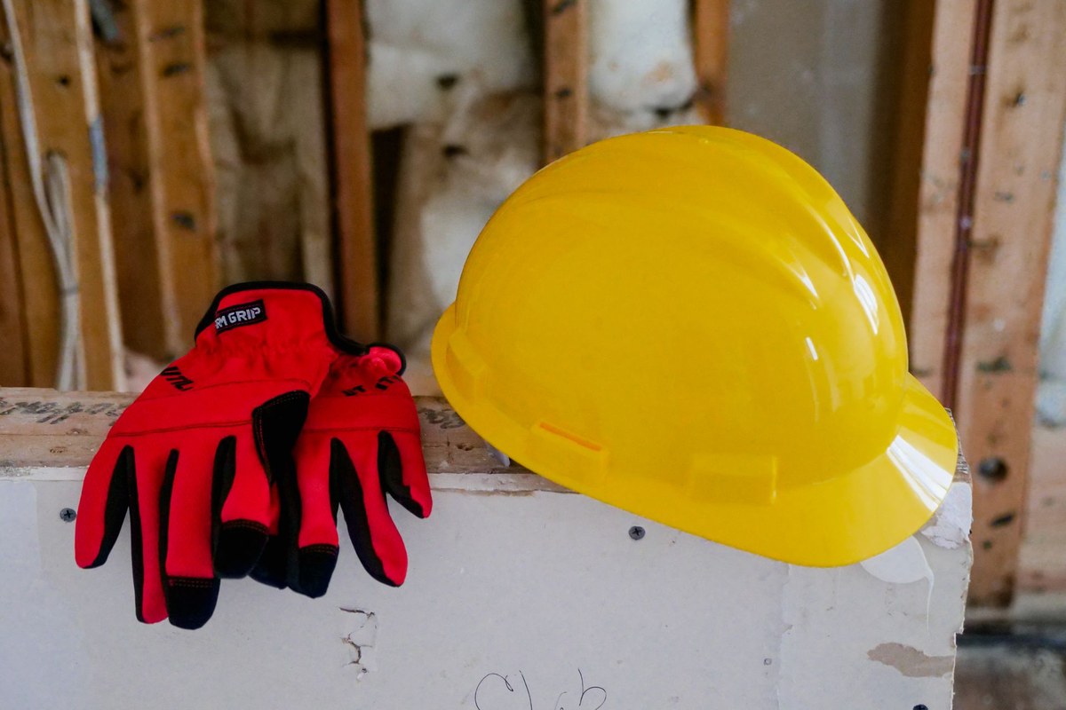 Gants de travail et casque de chantier posés côte à côte, illustration des revenus irréguliers en intérim