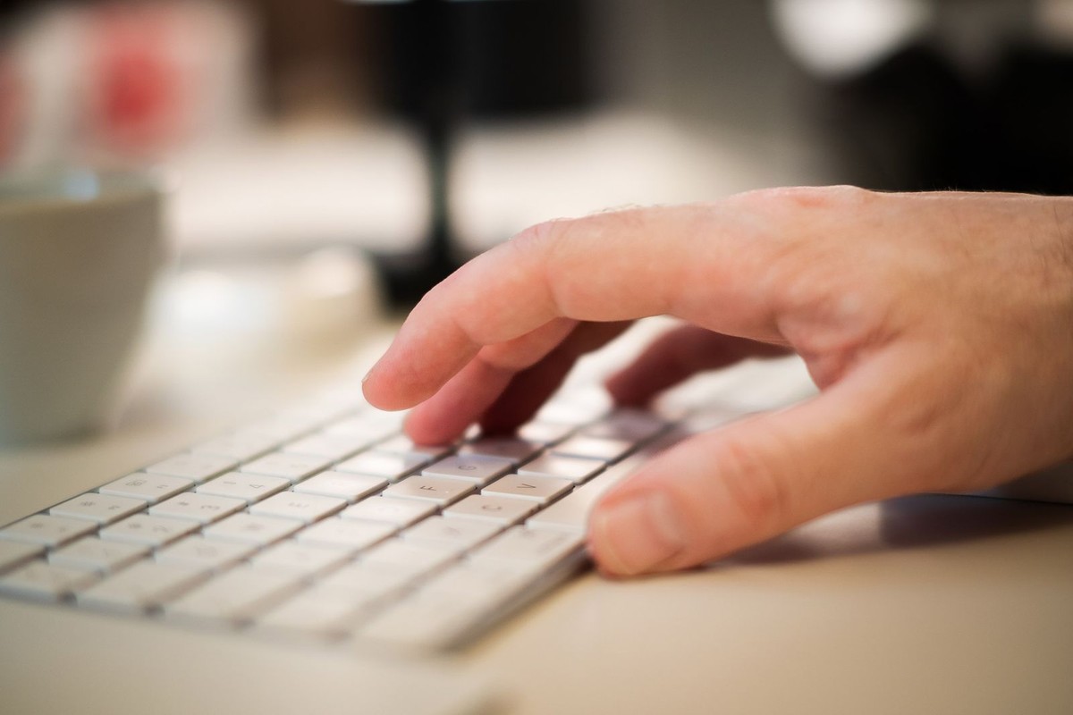 Main tapant sur un clavier d'ordinateur pour consulter son relevé de carrière en ligne.