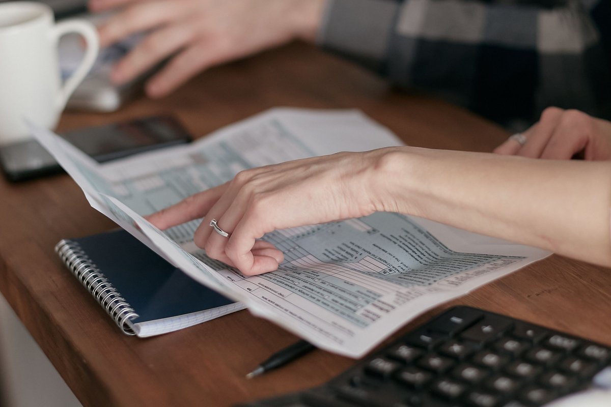 Mains et calculatrice pour comparer les assurances-vie sur leurs frais entre deux contrats