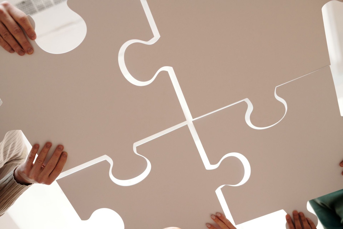 Plusieurs mains assemblant des pièces de puzzle, symbole d'une carrière hachée qui compte quand même pour la retraite.